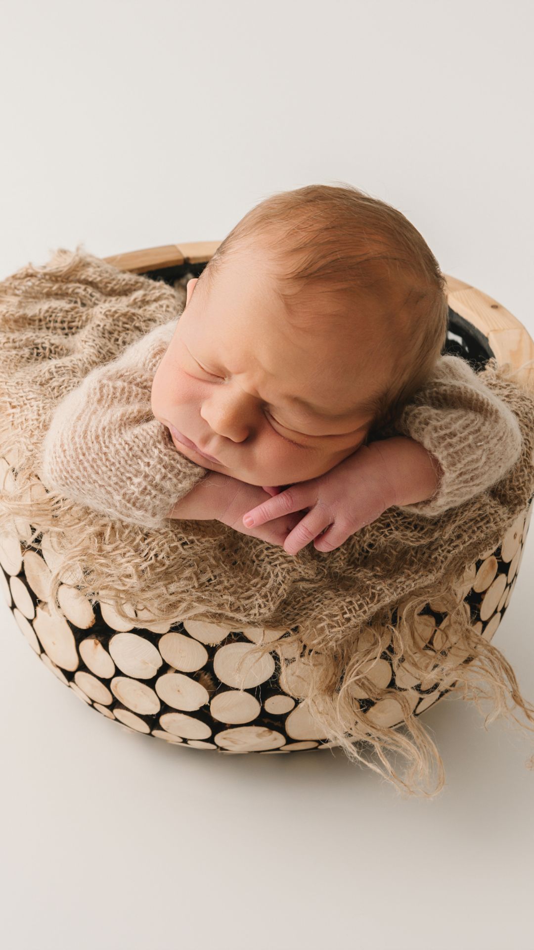pasgeboren baby geposeerd in houten schaal