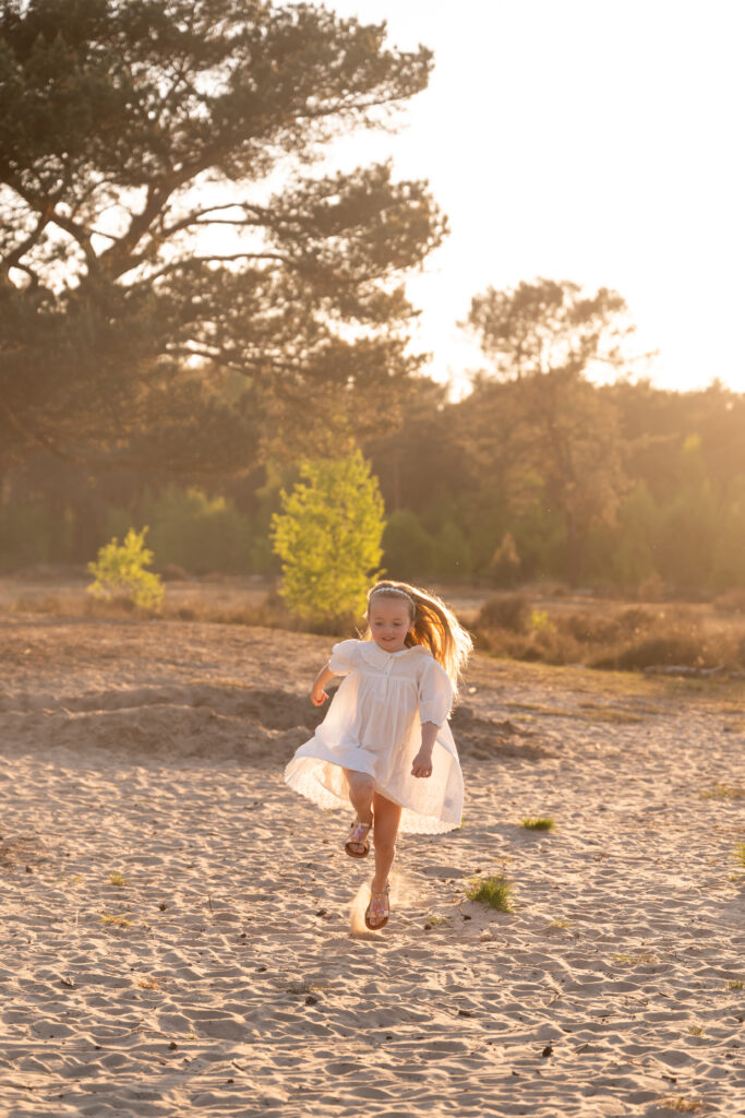 spontane foto van lopend meisje op de heide bij zonsondergang of golden hour gemaakt door Digidroom, fotograaf in Oostmalle (Malle), Antwerpen